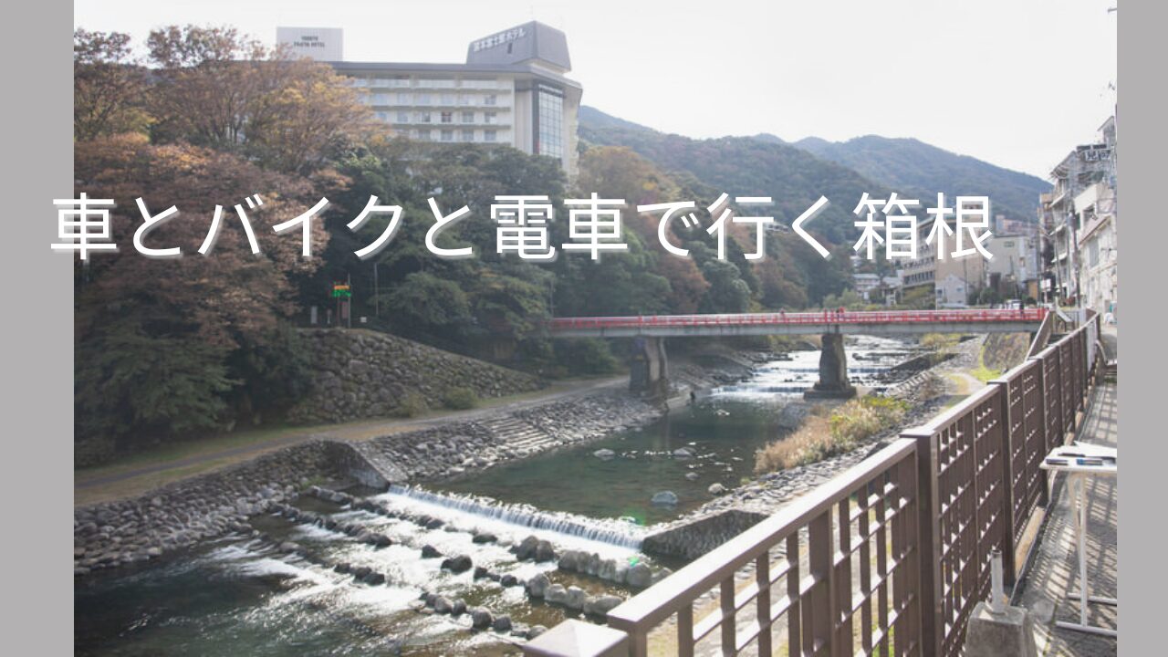 箱根湯本の川沿いにかかる赤い橋と山並みを写した風景